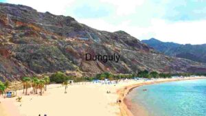 Serene Beachside Escape: A Panoramic View of Sandy Shores and Rugged Cliffs