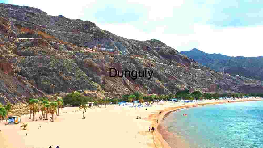 Serene Beachside Escape: A Panoramic View of Sandy Shores and Rugged Cliffs