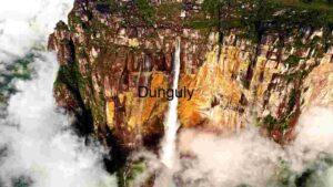 Majestic Waterfall Amidst Cloud-Kissed Cliffs