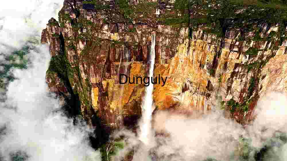 Majestic Waterfall Amidst Cloud-Kissed Cliffs