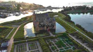 Aerial View of a Majestic Castle Surrounded by Water and Greenery