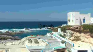 Coastal Mediterranean Scene with White Buildings and Rocky Shoreline