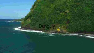 Helicopter Flying Along Lush Coastal Cliff