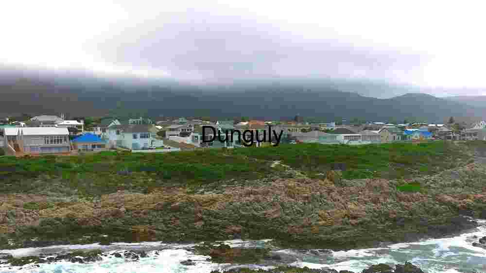 Coastal Village with Rocky Shoreline and Overcast Sky