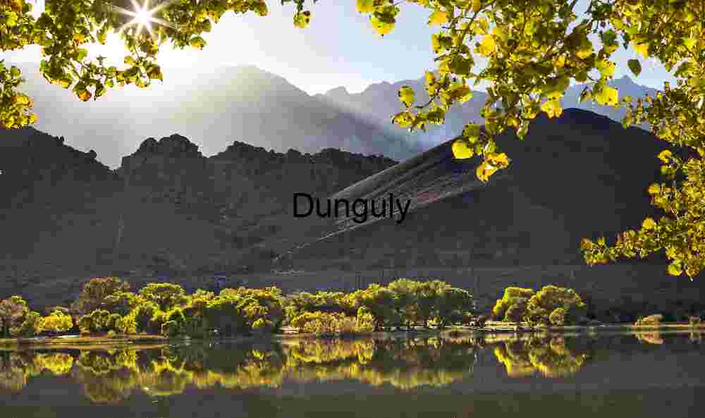 Sunlit Hills and Autumn Foliage Reflected in Serene Lake