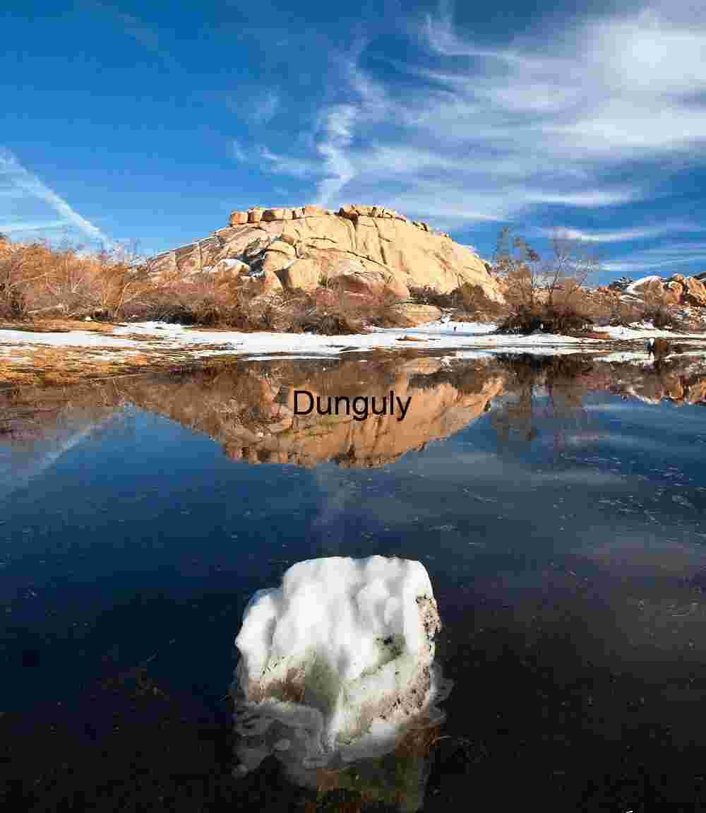 Reflected Stillness: Snow-Dusted Desert Hill and Calm Waters