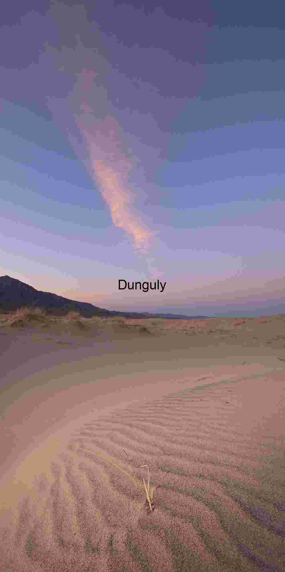 Rippled Desert Dunes at Sunrise Beneath Pink Cloud