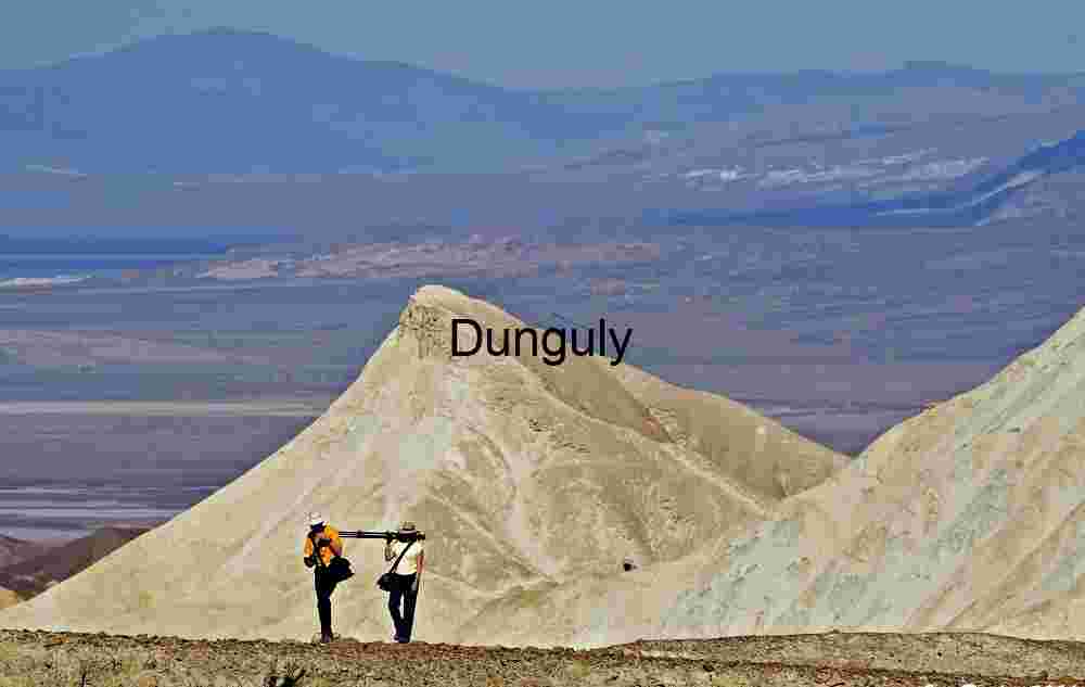 Traversing the Vastness: Hikers Amid Desert Peaks