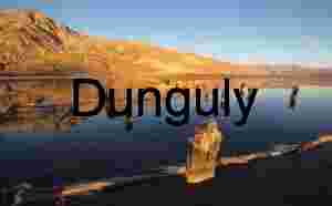 Weathered Wooden Posts in Reflective Lake at Sunset