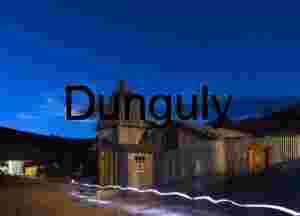 Rustic Ghost Town Under Starry Night Sky with Light Trail – Historic Mining Settlement Architecture