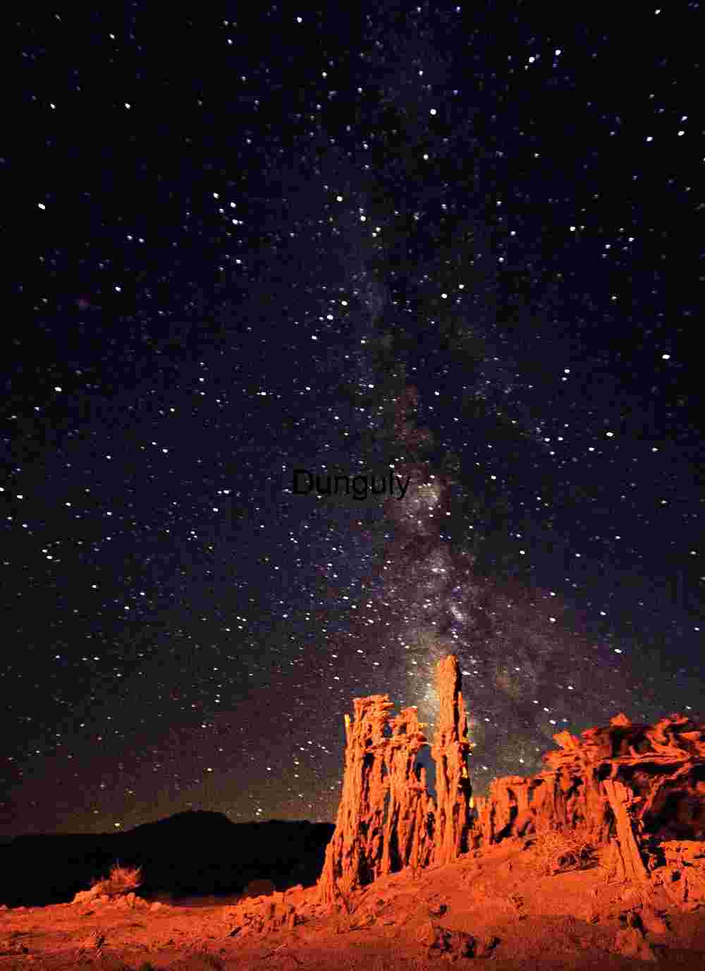 Milky Way Over Red‑Lit Desert Rock Formations