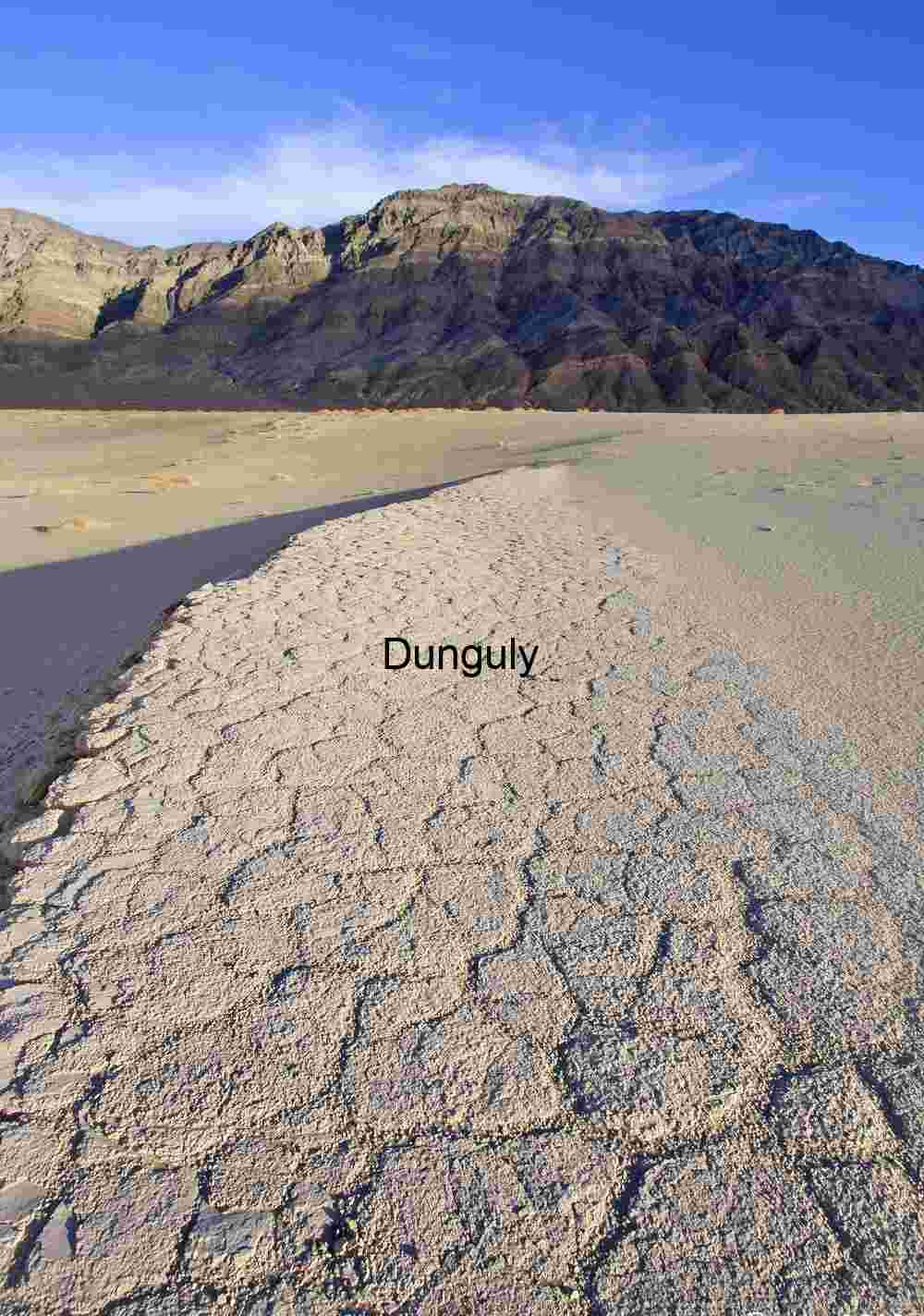 Cracked Silence: Parched Earth Beneath Mountain Shadows