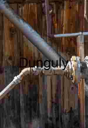 Rustbound Junction: Industrial Piping Against Weathered Timber