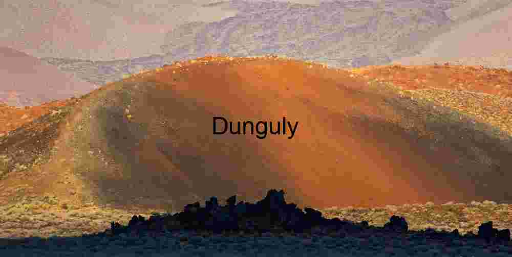 Cinder Cone Volcano – Sunlit Ash Slope & Jagged Lava Rocks in Desert Terrain
