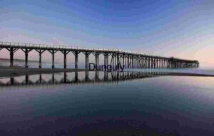 Linear Calm: Wooden Pier Reflected in Coastal Stillness