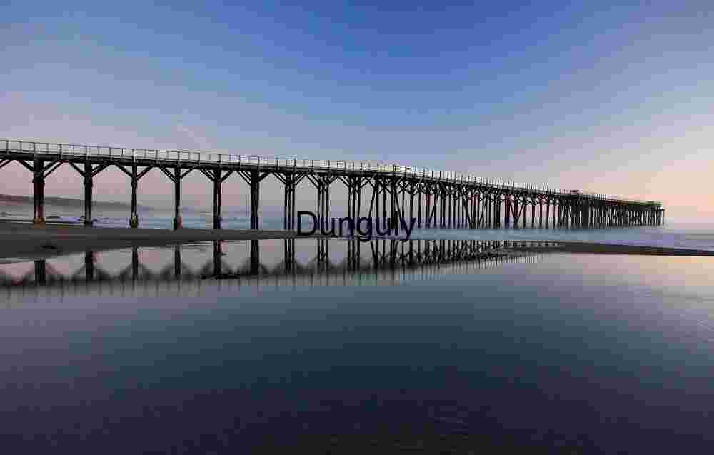 Linear Calm: Wooden Pier Reflected in Coastal Stillness
