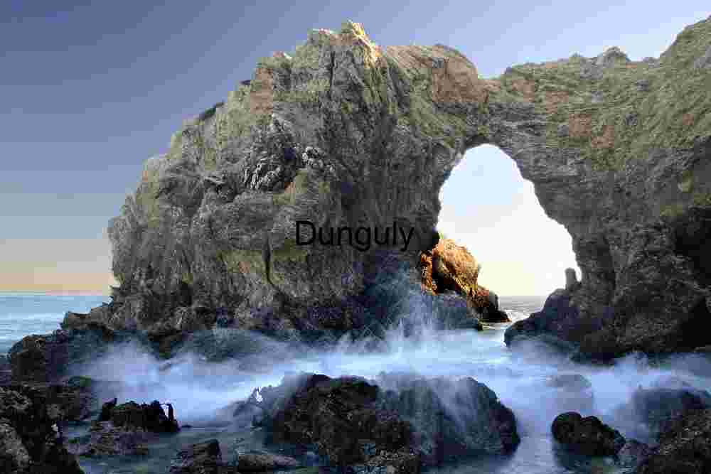 Erosion’s Gateway: Ocean Arch Framed by Surf and Sky