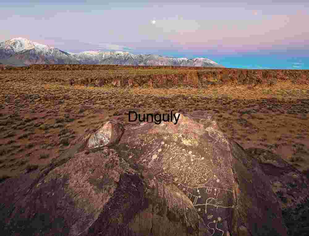 Twilight Petroglyphs: Ancient Symbols on Desert Stone Beneath Moonlit Peaks