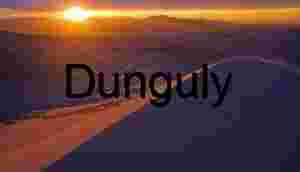 Sunset Over Sculpted Desert Dunes and Silhouetted Mountains