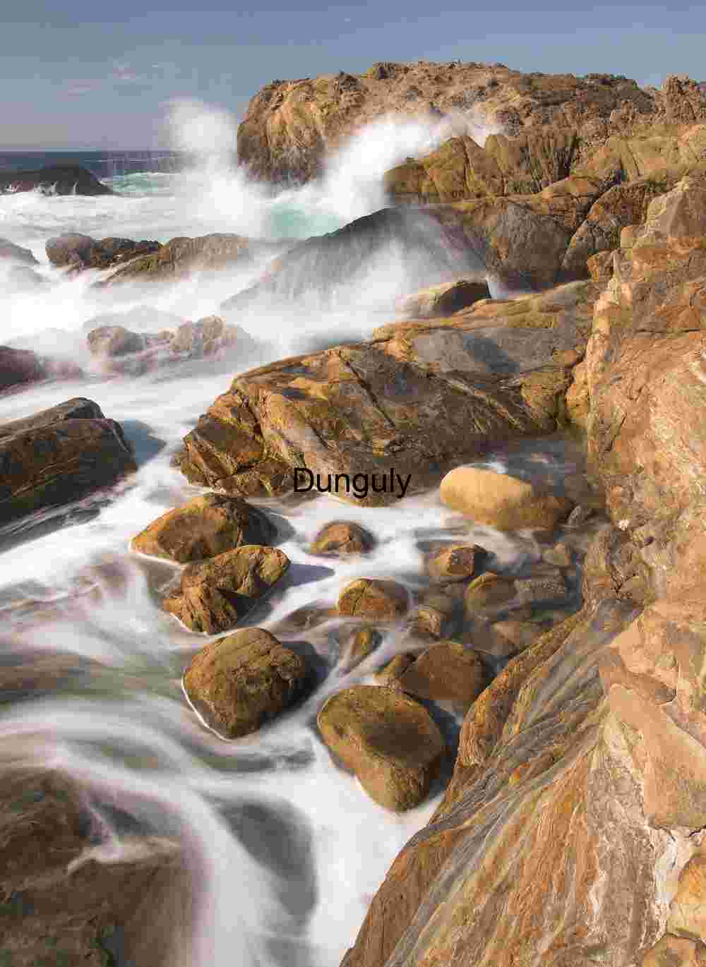 Crashing Waves Over Weathered Coastal Rocks