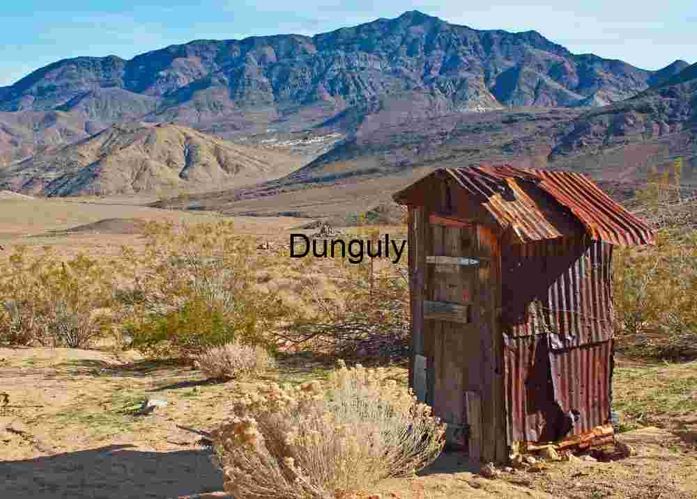 Shelter in Silence: Rusted Outhouse Beneath Desert Peaks