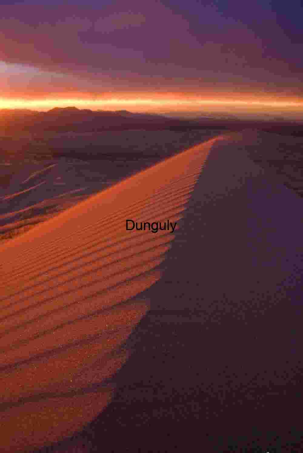 Sunlit Desert Dune with Dramatic Sky and Wind-Carved Ridges