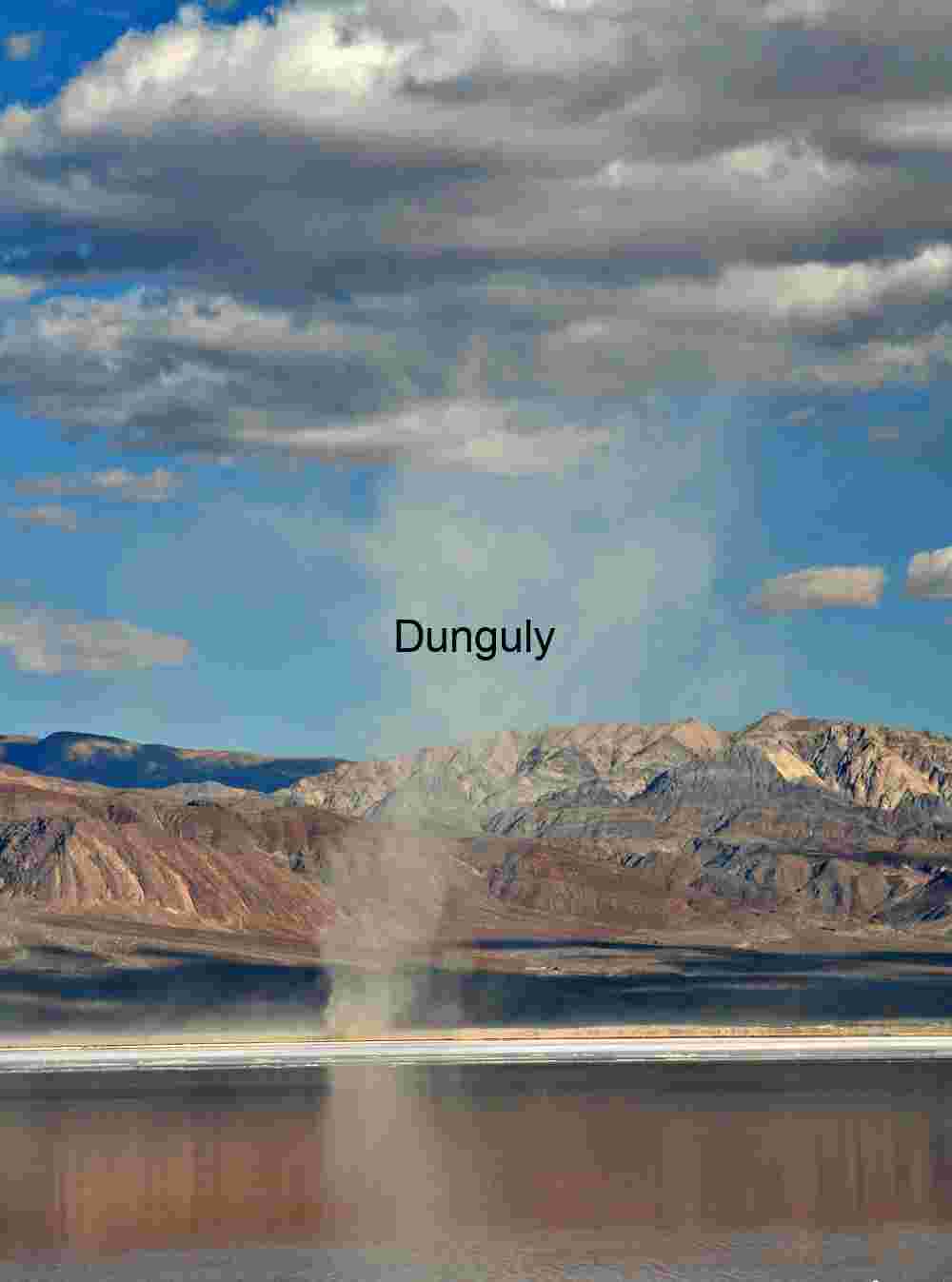 Atmospheric Phenomenon: Dust Devil Rising Over Desert Lakebed with Mountain Backdrop