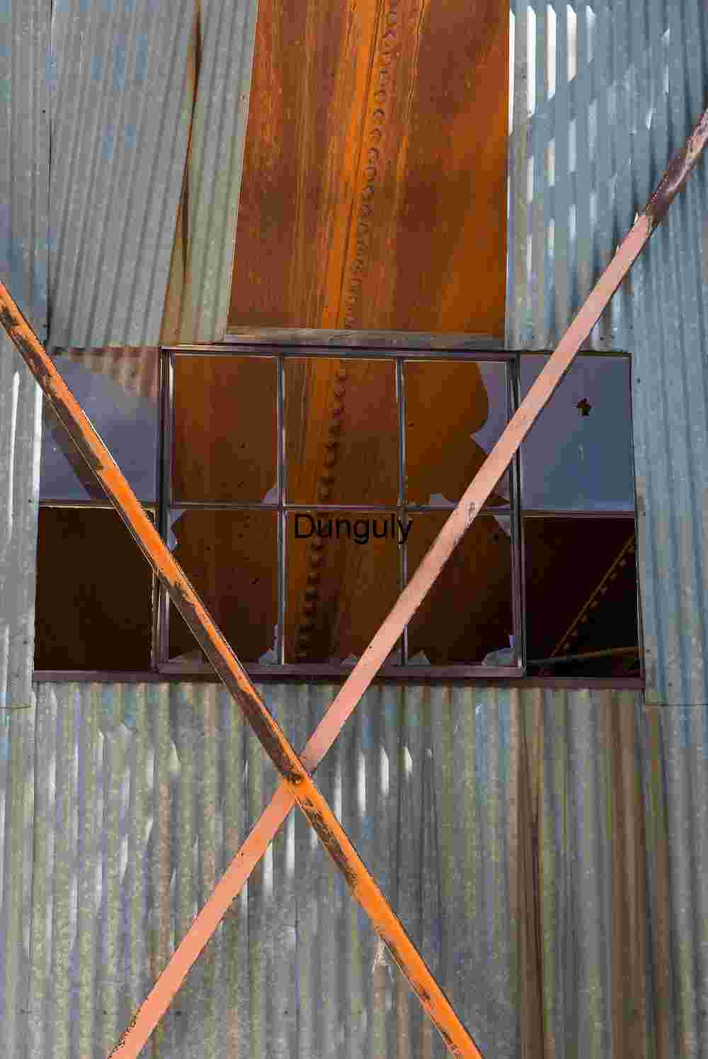 Broken Window and Rusted Beams on Corrugated Wall