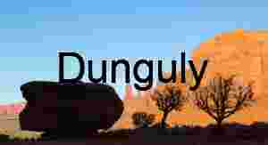 Balanced rock and two trees silhouetted against the Three Sisters at sunrise