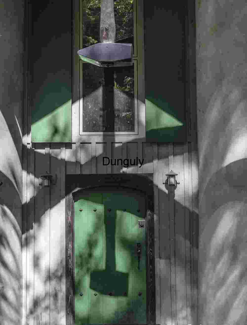 Dramatic Hammer Shadow on Green Door: Light & Architecture