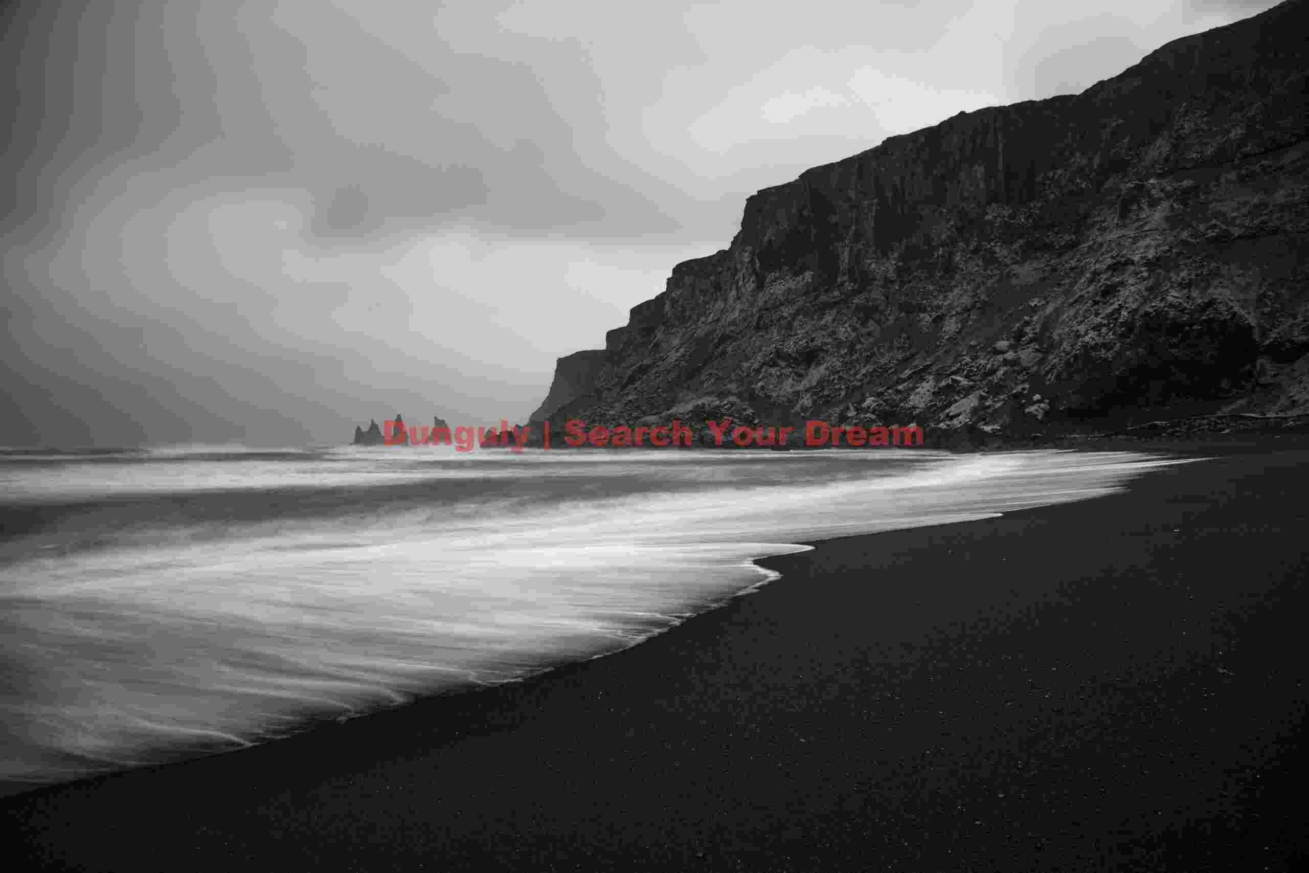 Receding surf patterns, black sand beach and Reynisdrangar sea stacks; Vik, South Iceland