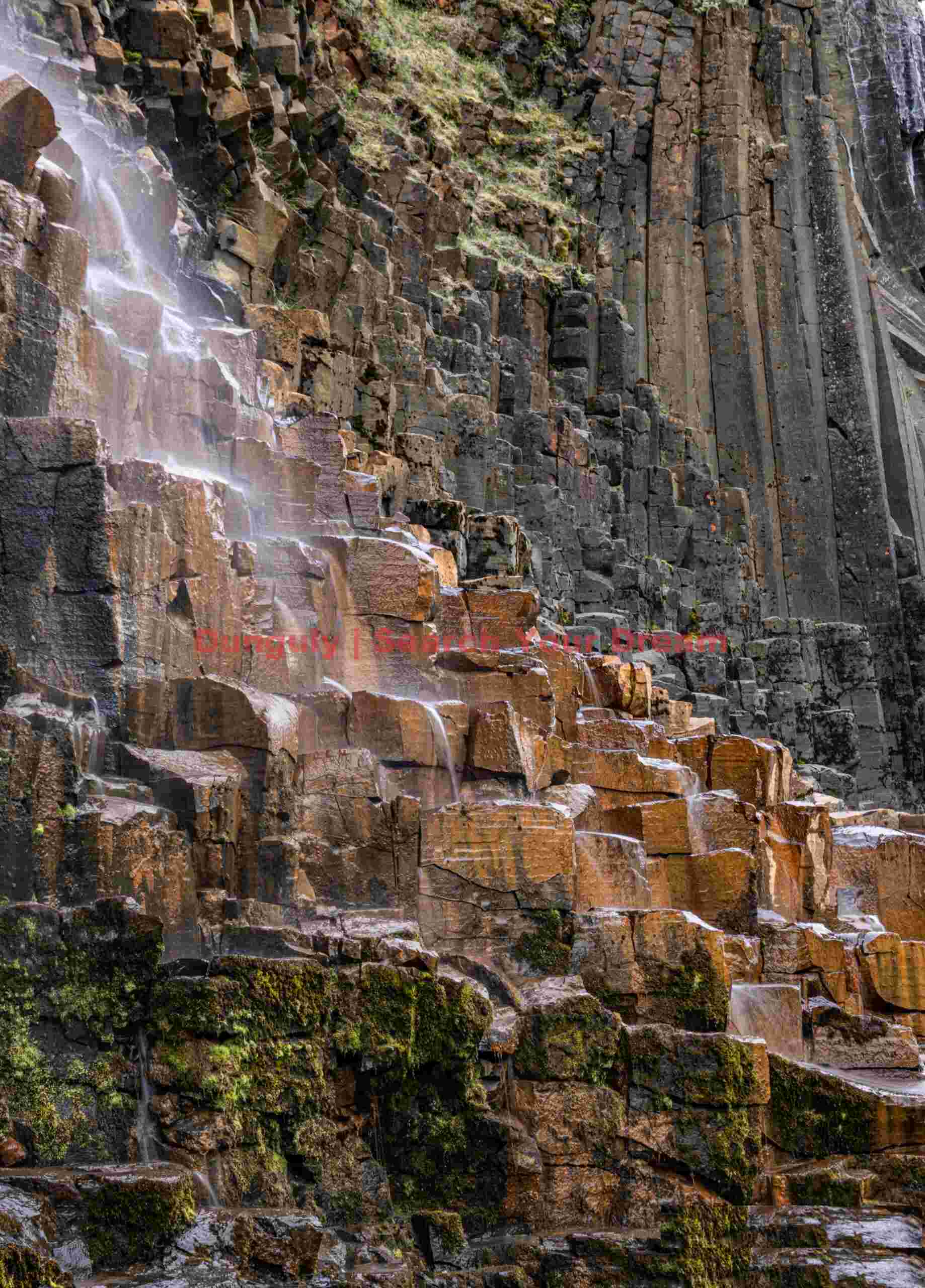 Majestic Waterfall: Small waterfall over orange basalt columns