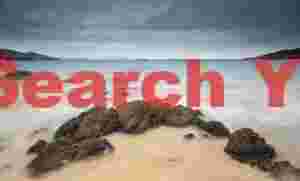 Aquamarine sea and crescent of boulders