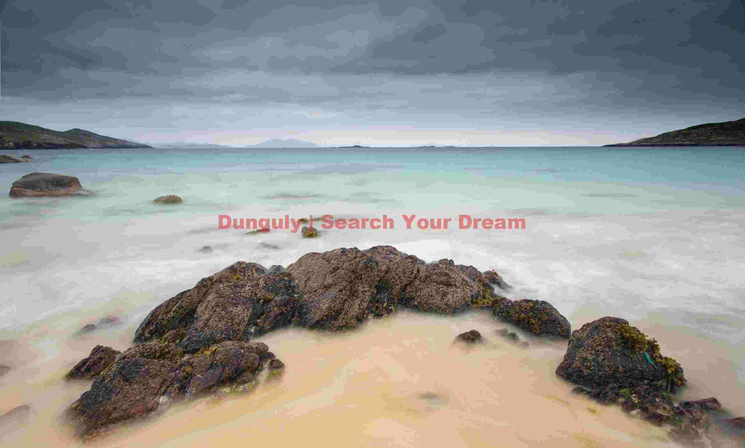 Aquamarine sea and crescent of boulders