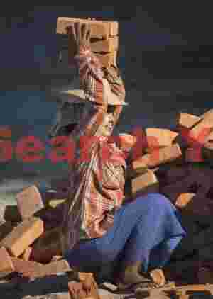 Girl carrying bricks on her head