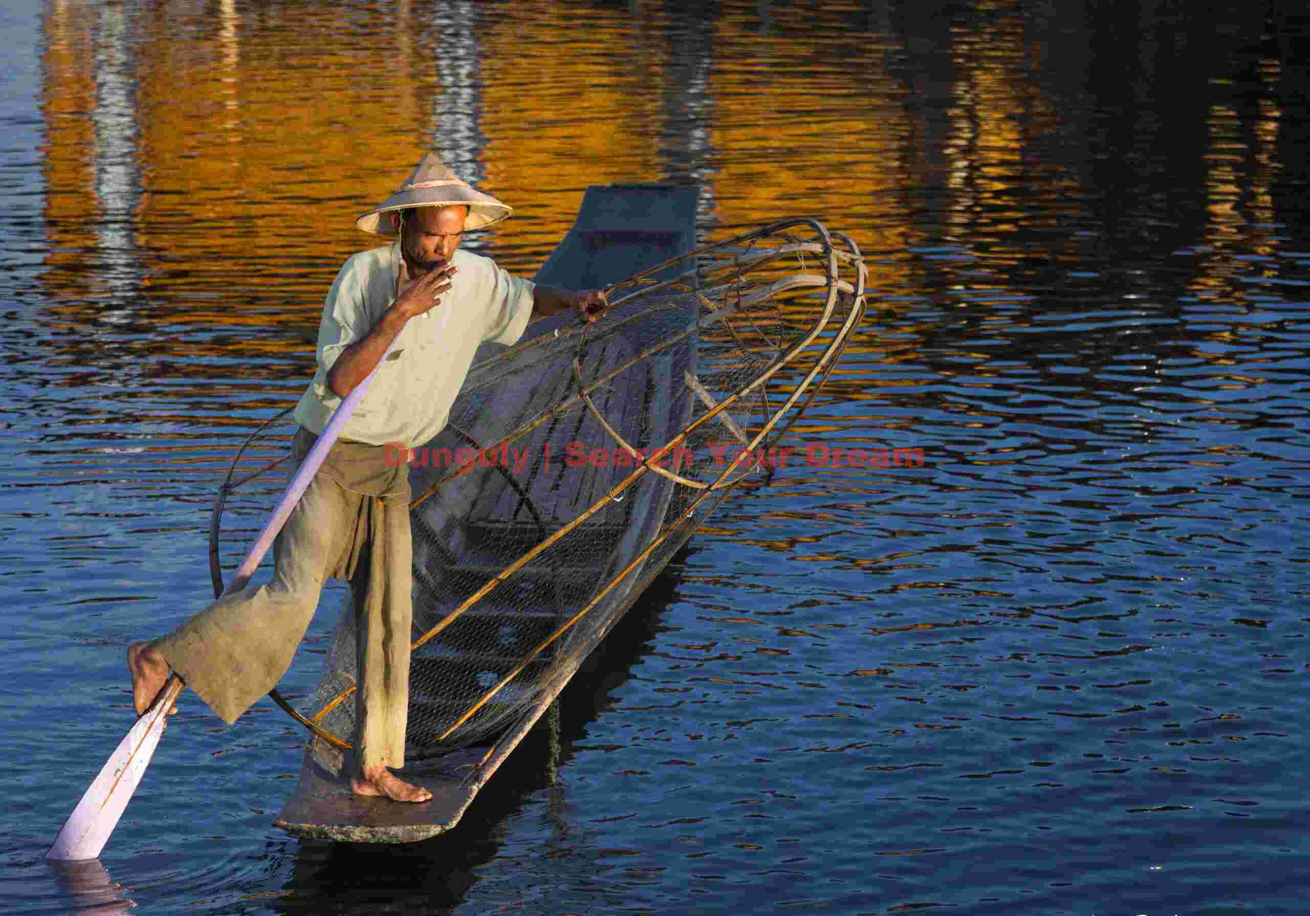 Leg-rowing fisherman and golden refections
