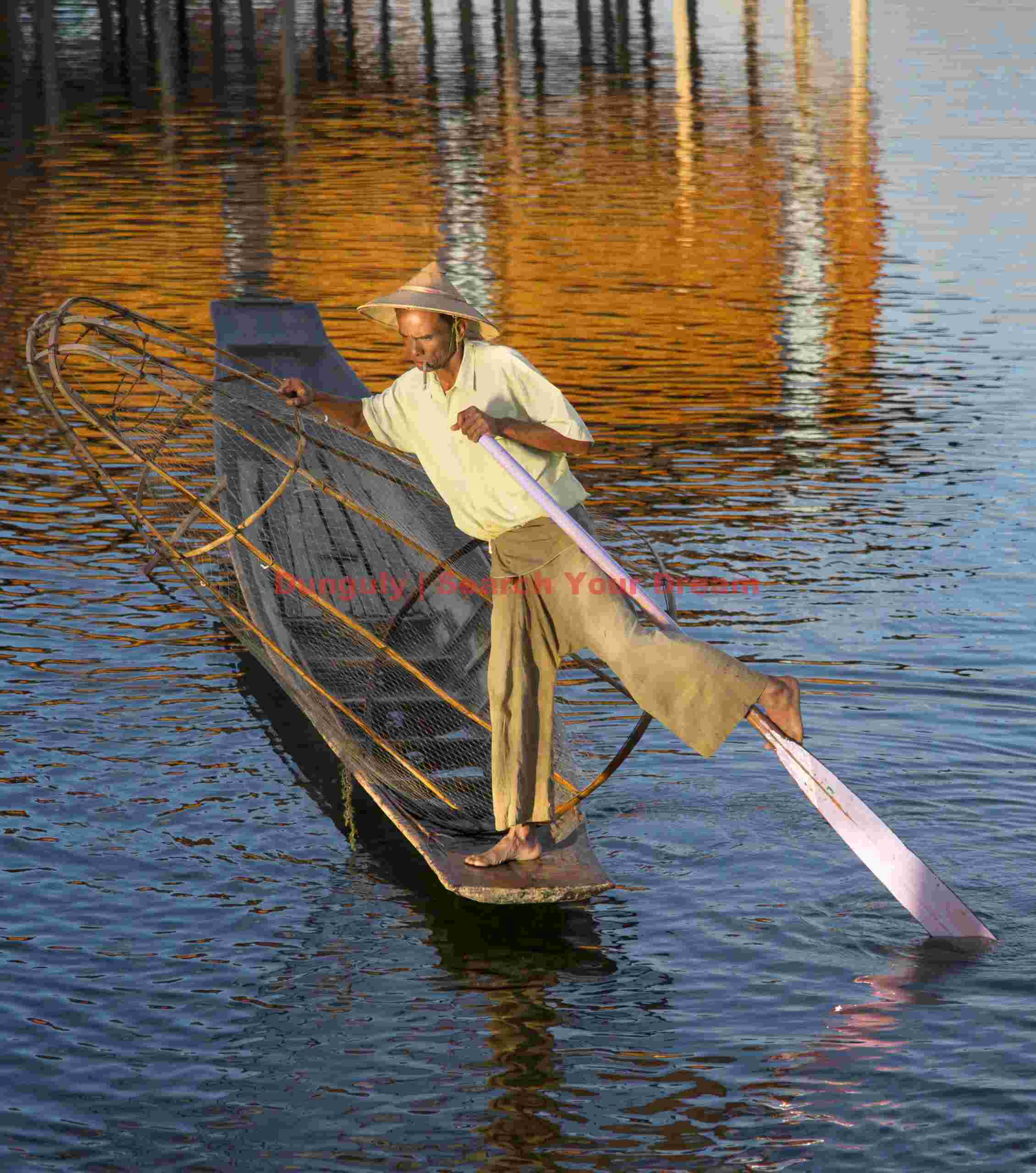 Leg-rowing fisherman and golden reflections