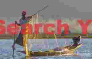 Leg-rowing fisherman with backlit net
