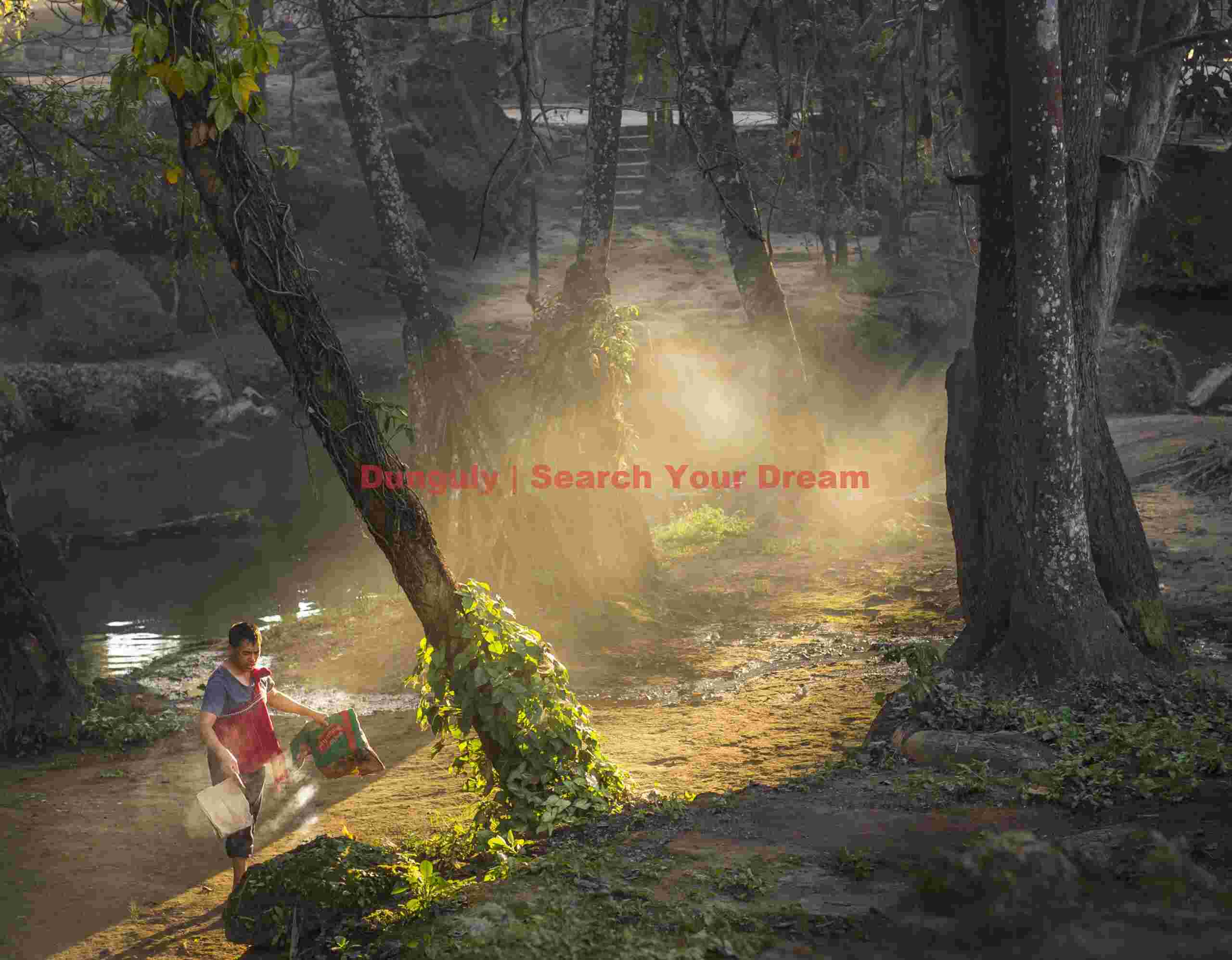 Man clearing and burning leaves and trash on riverbank