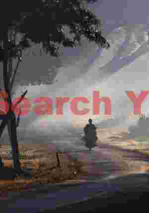 Moped rider on a misty morning by the lake